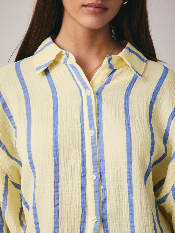 Close-up of a person wearing a yellow and blue striped shirt.