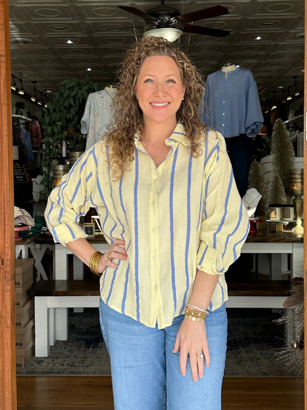 Woman wearing a yellow and blue striped shirt in a store setting