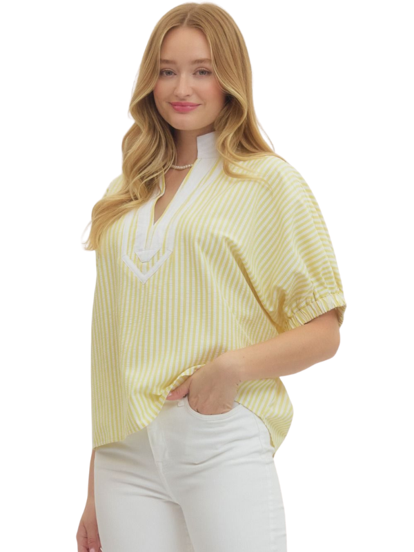 Woman wearing a yellow striped blouse with white trim on a white background